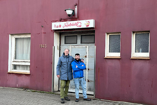 Mario Peterscheck (rechts) und Adrian Wolf vor der Produktionshalle ihres Backbetriebes (Foto Credit: Inselgenossenschaft Helgoland eG)